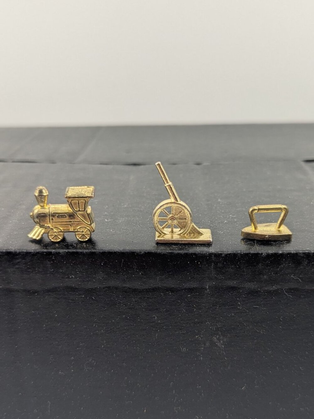 Three gold color monopoly replacement pieces train, canon, iron